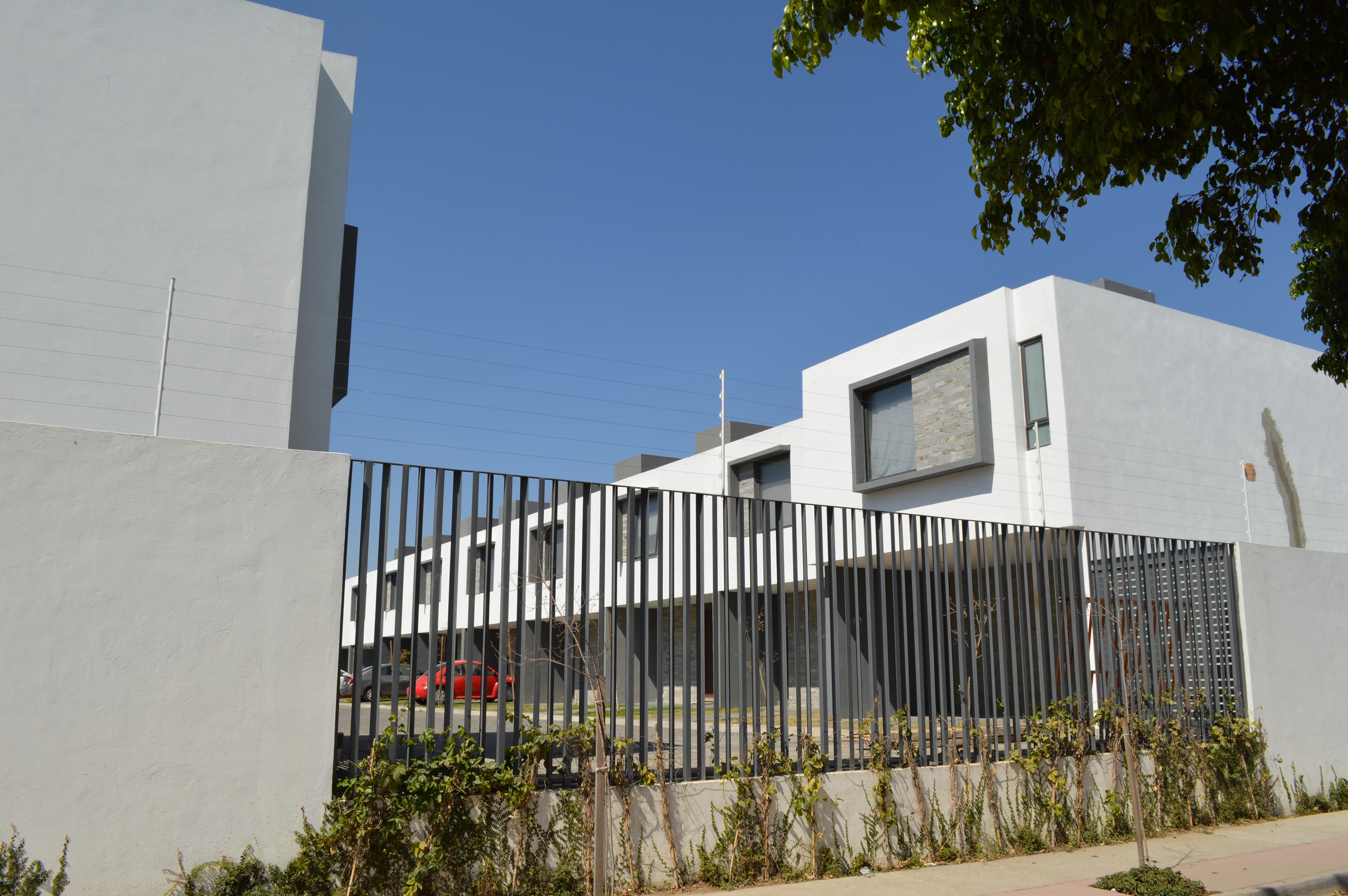 Detalle de una cerca eléctrica correctamente instalada sobre muro: altura sobre la barda, líneas del cordón y señalización