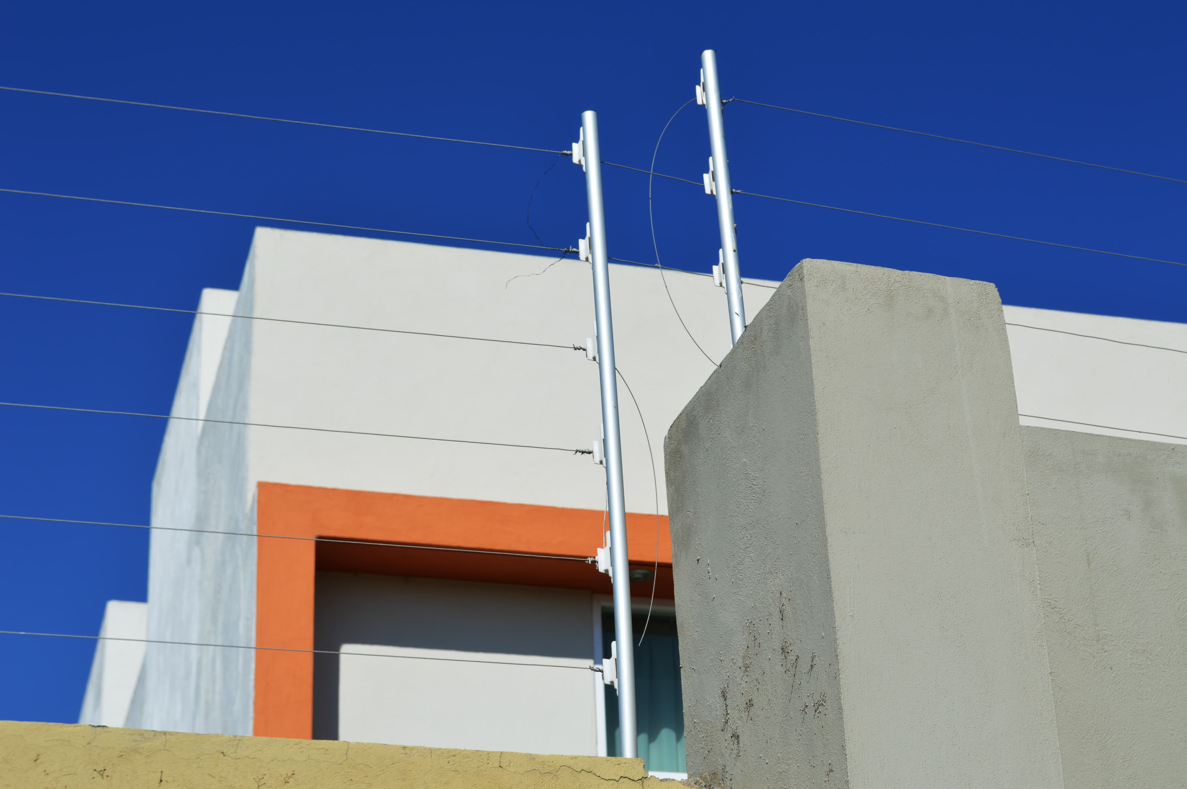 Cerca eléctrica de seguridad montada sobre una barda residencial.