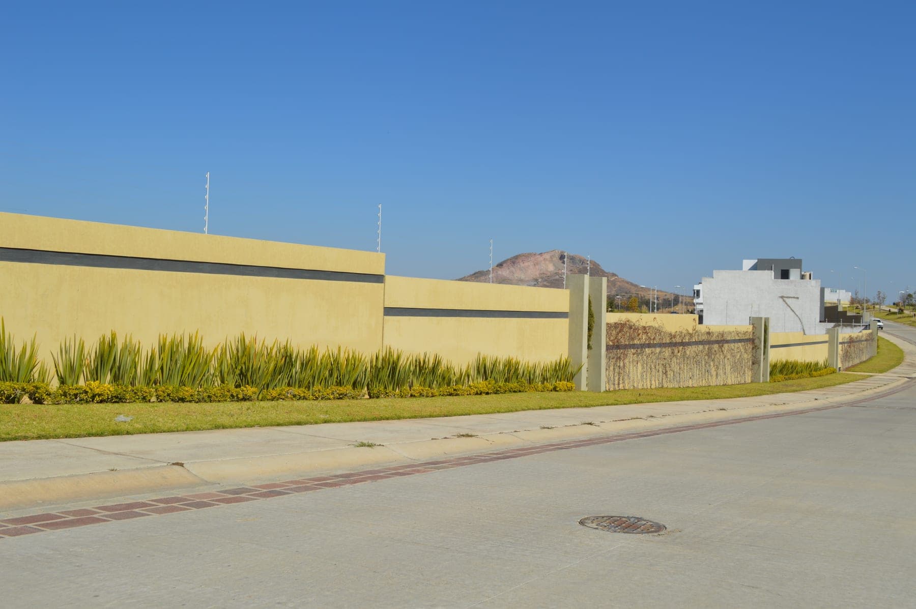 Cerca eléctrica corriendo a lo largo de una barda extensa sobre la calle