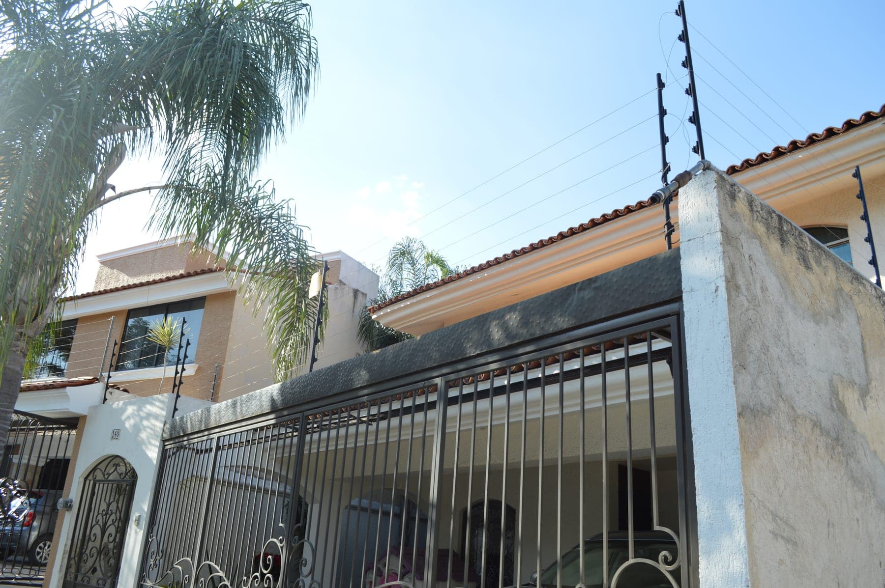 Cerca eléctrica sobre el portón y la barda de acceso a una residencia