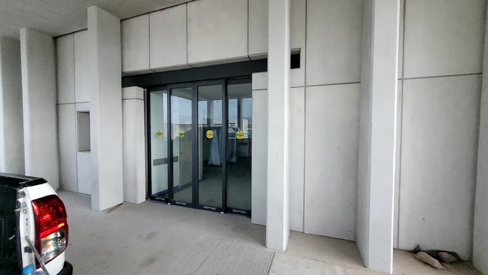 Puerta automática Hermetic de cristal que sella el vano para conservar el clima interior, instalada en el acceso de un edificio
