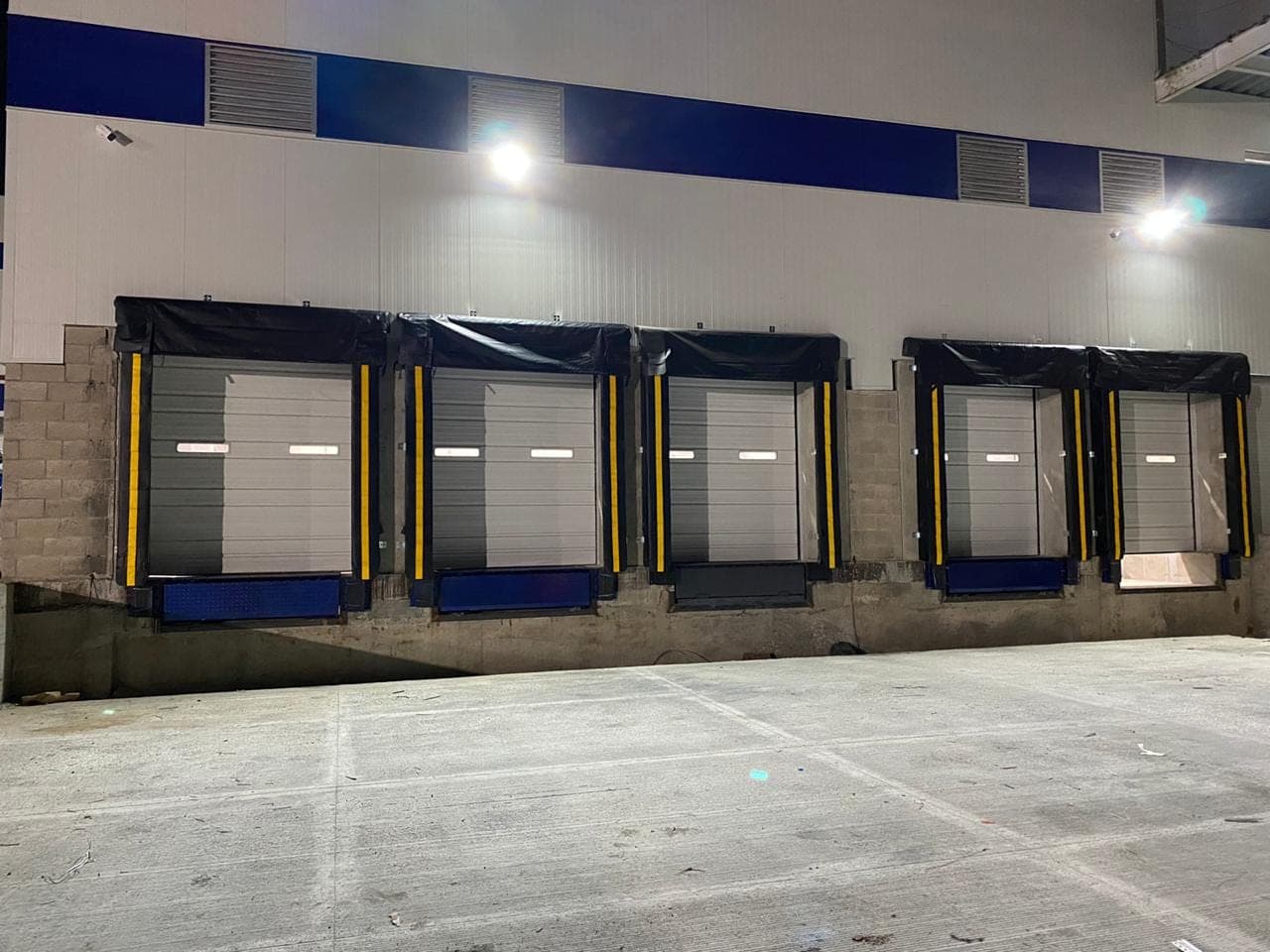 Instalación completa de cinco bahías de carga con rampa niveladora hidráulica, tope de hule, sello de andén y cortina de acero